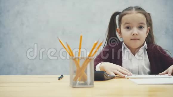 年轻的头发硬的女孩坐在桌子旁在这题词的手中考试看上去很糟糕视频的预览图