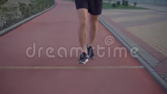 男子慢跑者正在公园里的运动道上移动手里拿着健身跟踪器视频的预览图