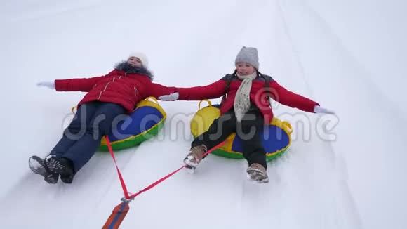 快乐的女孩在冬天的公园里雪橇和休息为圣诞假期冬天穿红色夹克的孩子们乘雪视频的预览图
