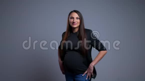 怀孕的白种人年轻女性的特写照片她兴奋地看着镜头双手放在臀部视频的预览图