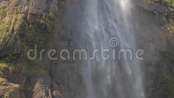 水落在高高的棕色岩石悬崖上绿树成荫视频的预览图