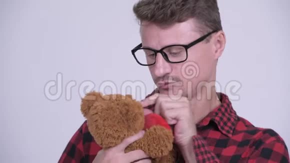 长胡子的嬉皮士拿着泰迪熊表现得很童趣视频的预览图