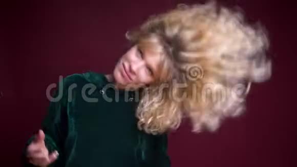 年轻美丽的白种人女性的特写镜头在她的金发和欢快的舞蹈面前辗转视频的预览图