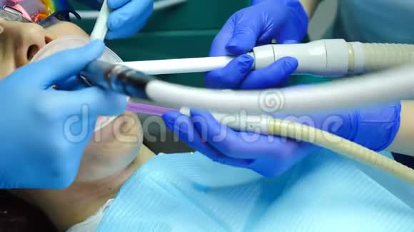 在现代牙医办公室牙科手术的特写镜头女性患者接受牙齿治疗牙医使用工具视频的预览图