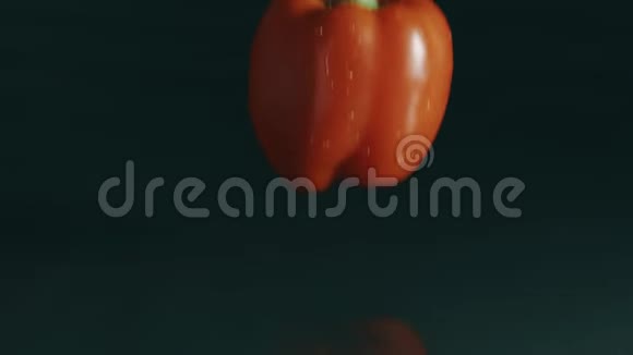 甜椒落在潮湿的表面上的深色背景红色慢镜头视频的预览图