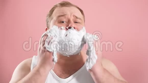 令人惊讶的男人脸上有剃须泡沫对新的剃须凝胶印象深刻动作缓慢视频的预览图