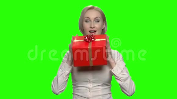 可爱成熟的商业女性崇拜她的红色礼品盒视频的预览图