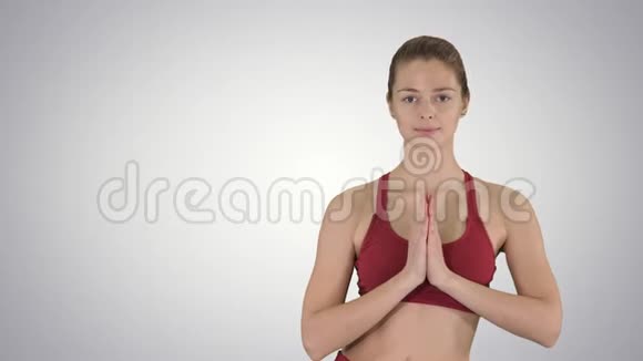 年轻女性做瑜伽运动UtthitaHastaPadangustasana在梯度背景下视频的预览图