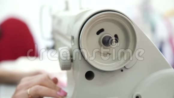 缝纫机操作过程中已婚妇女手旋转轮的特写视频的预览图