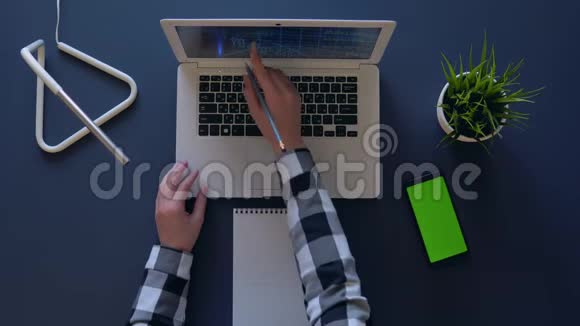 商务女性使用笔记本电脑和手机旁边的笔记本来考虑收入空中射击视频的预览图