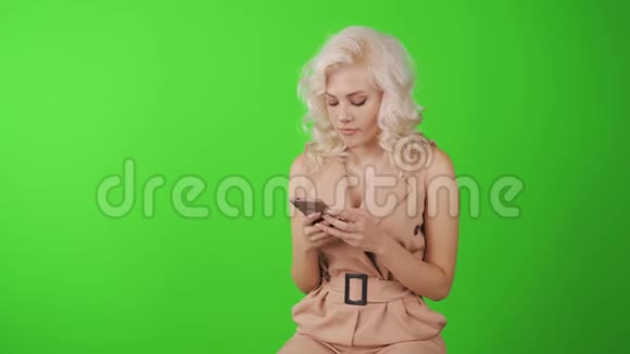 快乐的年轻女人在智能手机上聊天一个女人在绿色的背景下2她聊天时对男朋友有反应视频的预览图