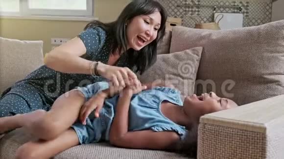 爱年轻的母亲笑着拥抱微笑可爱有趣的孩子女儿在家享受时光幸福的家庭视频的预览图