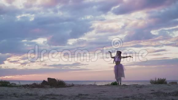 可爱的年轻女子妆容闪闪发光穿着粉红色的连衣裙在河岸上跳舞一个温柔女孩的舞蹈视频的预览图