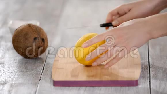 女厨师手在木切板上切芒果视频的预览图