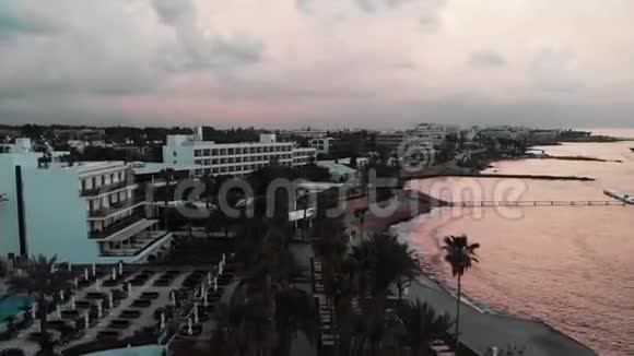 日落时分Drone乘坐酒店和棕榈树在旅游区附近飞行视频的预览图