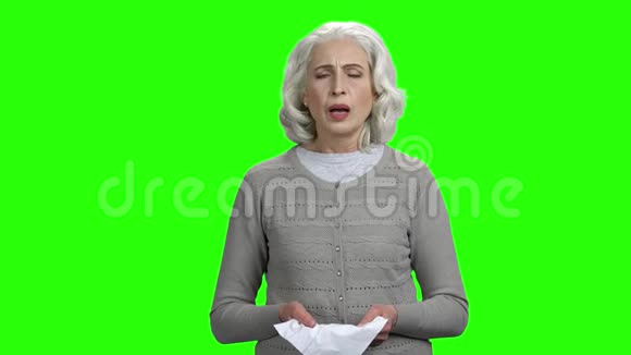 老年妇女在绿色屏幕背景上打喷嚏视频的预览图