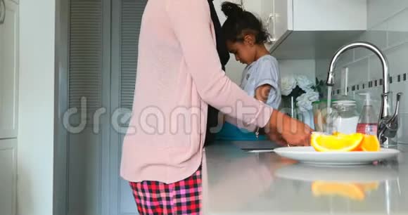 年轻母亲在家厨房洗碗视频的预览图