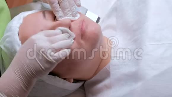 为一个亚洲女人准备化妆品或医疗程序戴着白手套的美容师或实验室助理的手视频的预览图