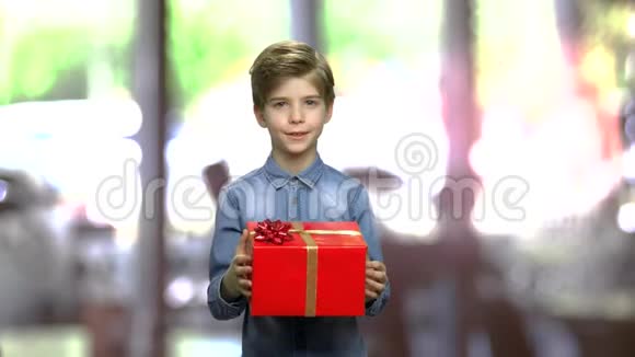 可爱的男孩递红礼盒视频的预览图