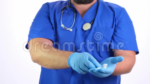 留胡子的医生穿着蓝色衣服戴着蓝色橡胶手套手里拿着白色药丸给你一个白色的视频的预览图
