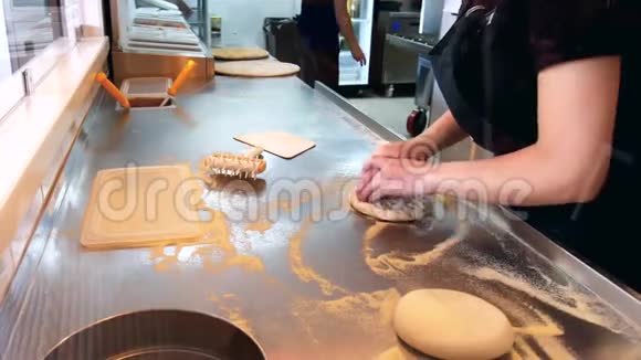 比萨饼师在餐馆里准备面团做比萨饼拉伸面团视频的预览图