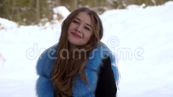 年轻美丽的女孩独自在冬天的森林里她在看摄像机女孩微笑着调情她高兴视频的预览图