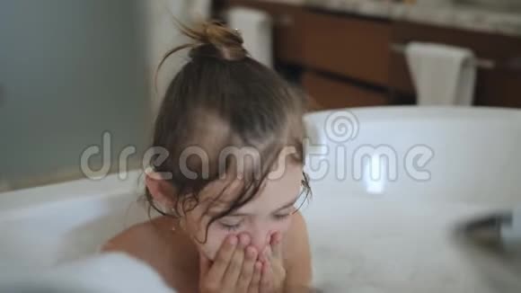 漂亮的三岁女孩洗澡湿发与浴沫可爱的金发孩子手里拿着泡沫视频的预览图