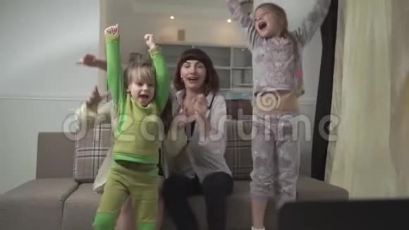 幸福的家庭在家为足球队加油一家人跳起来对进球感到高兴家庭节日快乐视频的预览图