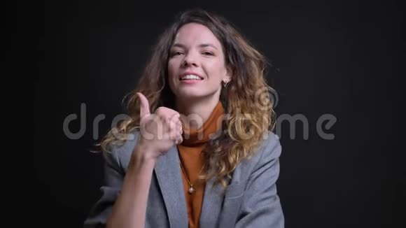 现代成功女性的特写肖像看着镜头微笑着点头竖起大拇指视频的预览图