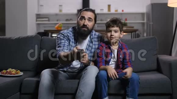 英俊的爸爸和儿子为电视遥控器而战视频的预览图