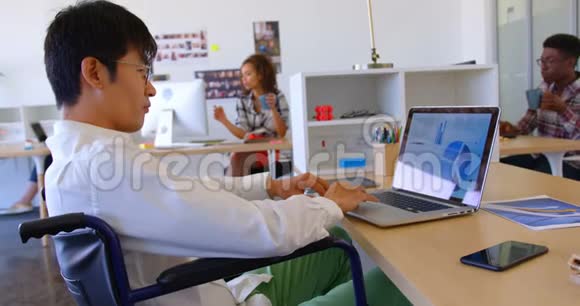 在现代办公室4k办公桌上使用笔记本电脑的残疾亚洲男性高管视频的预览图