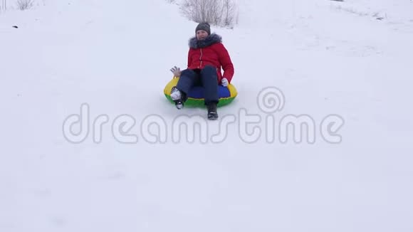 少女在雪碟上从高高的雪山上翻滚笑了起来新鲜空气中的冬季游戏圣诞节视频的预览图