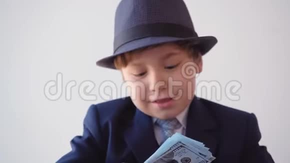 小男孩看起来像一个商人用放大镜检查美元视频的预览图