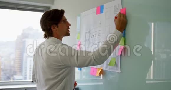 年轻的高加索男性高管在一个现代化的办公室里工作在玻璃板上视频的预览图