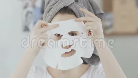 头上戴毛巾的女人脸上戴日本化妆面具照镜子视频的预览图