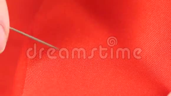女人用针和顶针在红布上缝制视频的预览图