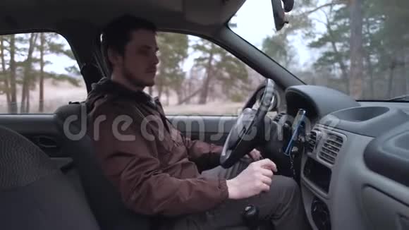 欧洲男人使用智能手机坐在车舱里视频的预览图