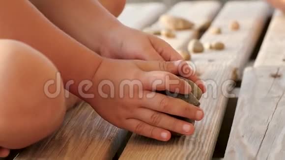 孩子在木架上玩石头孩子的手紧紧视频的预览图