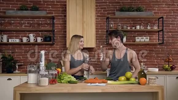 可爱的运动情侣在厨房里喝水视频的预览图