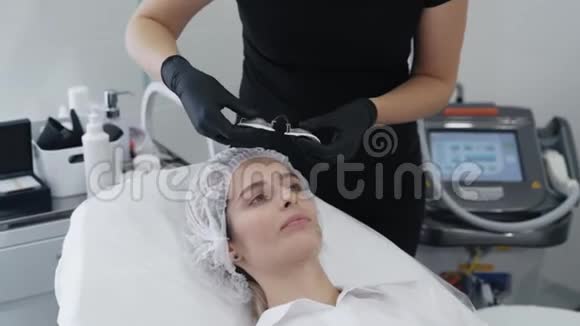 手套中的美容师慢动作的手在病人的眼睛上戴上特殊的防护眼镜视频的预览图
