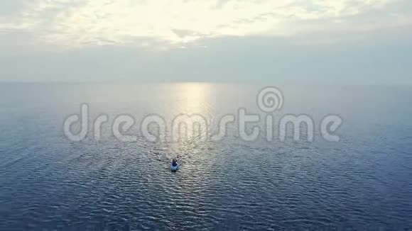 运动员日落时在海上游泳皮艇乘坐海上皮划艇的空中观景视频的预览图