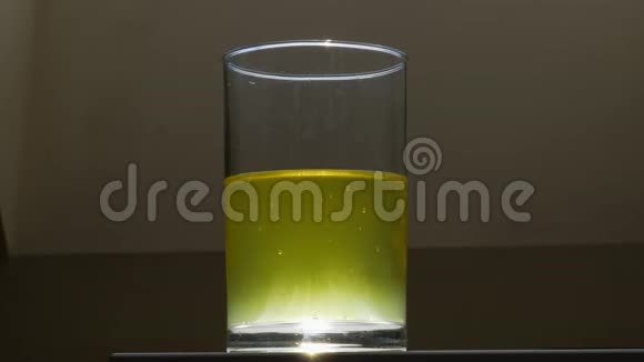 黄色的柠檬水倒在玻璃杯里女人或女人手拿一杯柠檬水关闭视野视频的预览图