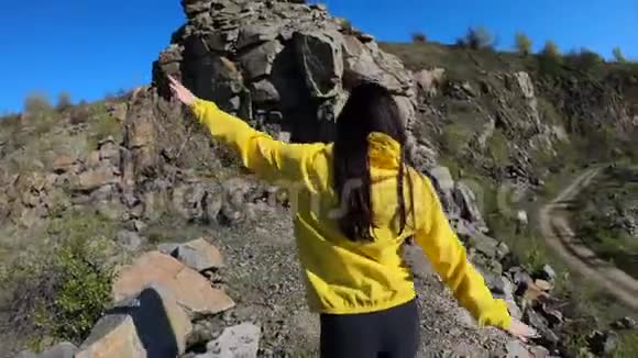 徒步旅行者女人登上山顶后景视频的预览图