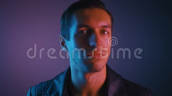 多色霓虹灯中男性的肖像在霓虹灯的晚会上年轻人的肖像视频的预览图
