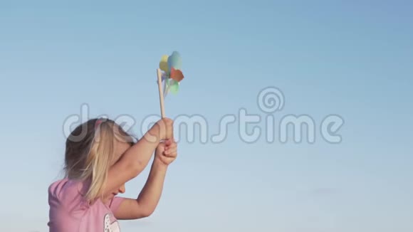 可爱快乐的女孩玩风车的肖像视频的预览图