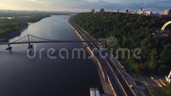 夏季城市沿江高速公路上行驶鸟瞰城市观光视频的预览图