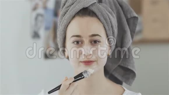 头戴毛巾的漂亮女人用刷子敷化妆品面膜视频的预览图