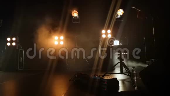 音乐会舞台的特写视频和上面的照明装置烟雾中的烟雾轻轻地打破了黄光和乳晕视频的预览图
