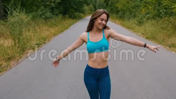 女孩慢跑者在森林道路上行走享受自由相信未来的成功自信视频的预览图