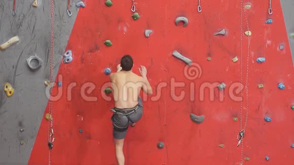自由野心勃勃的年轻人爬上人造墙慢动作视频的预览图